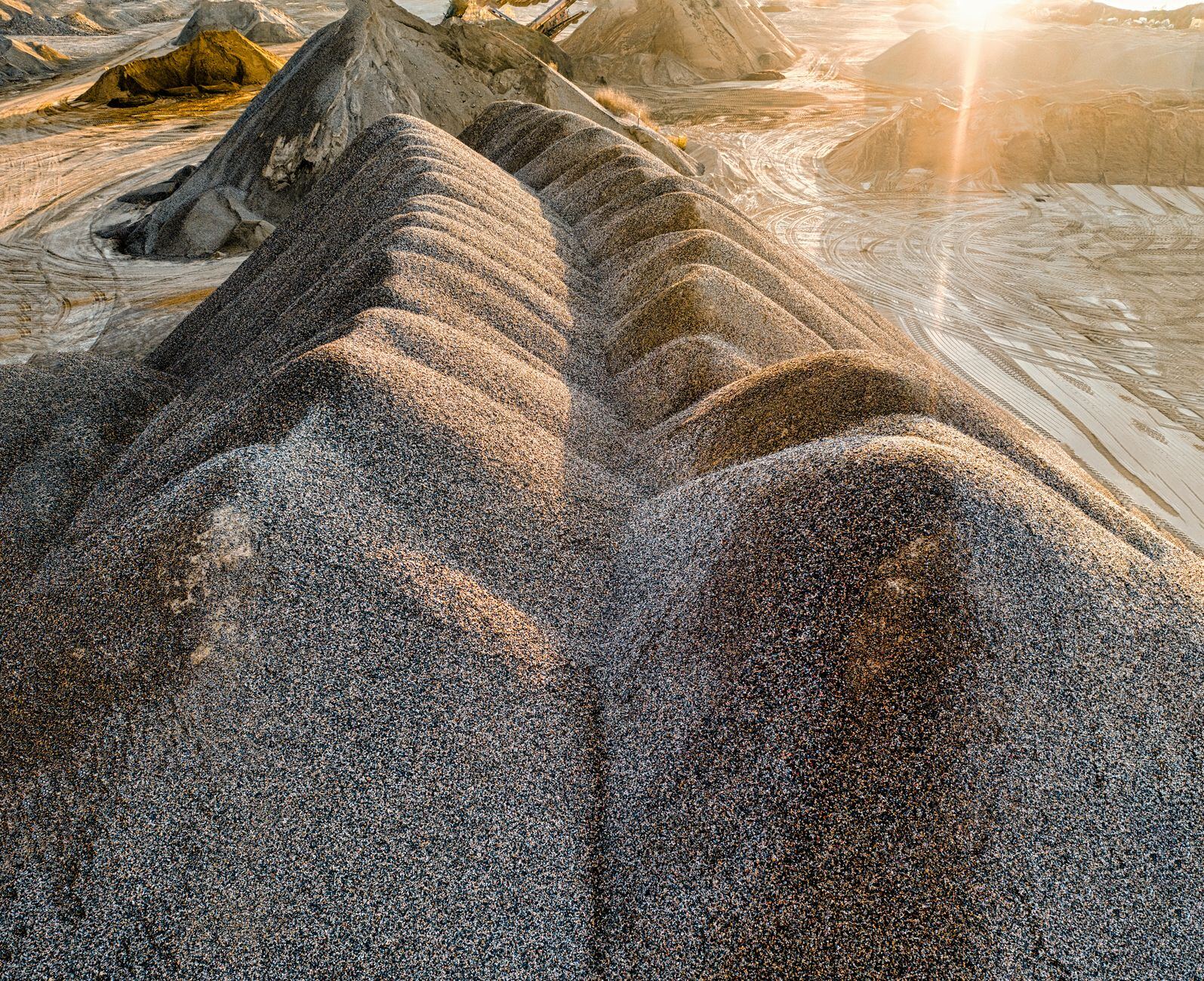 Drone shot of sunlit gravel formations in Rochester, MN quarry, showcasing natural textures.